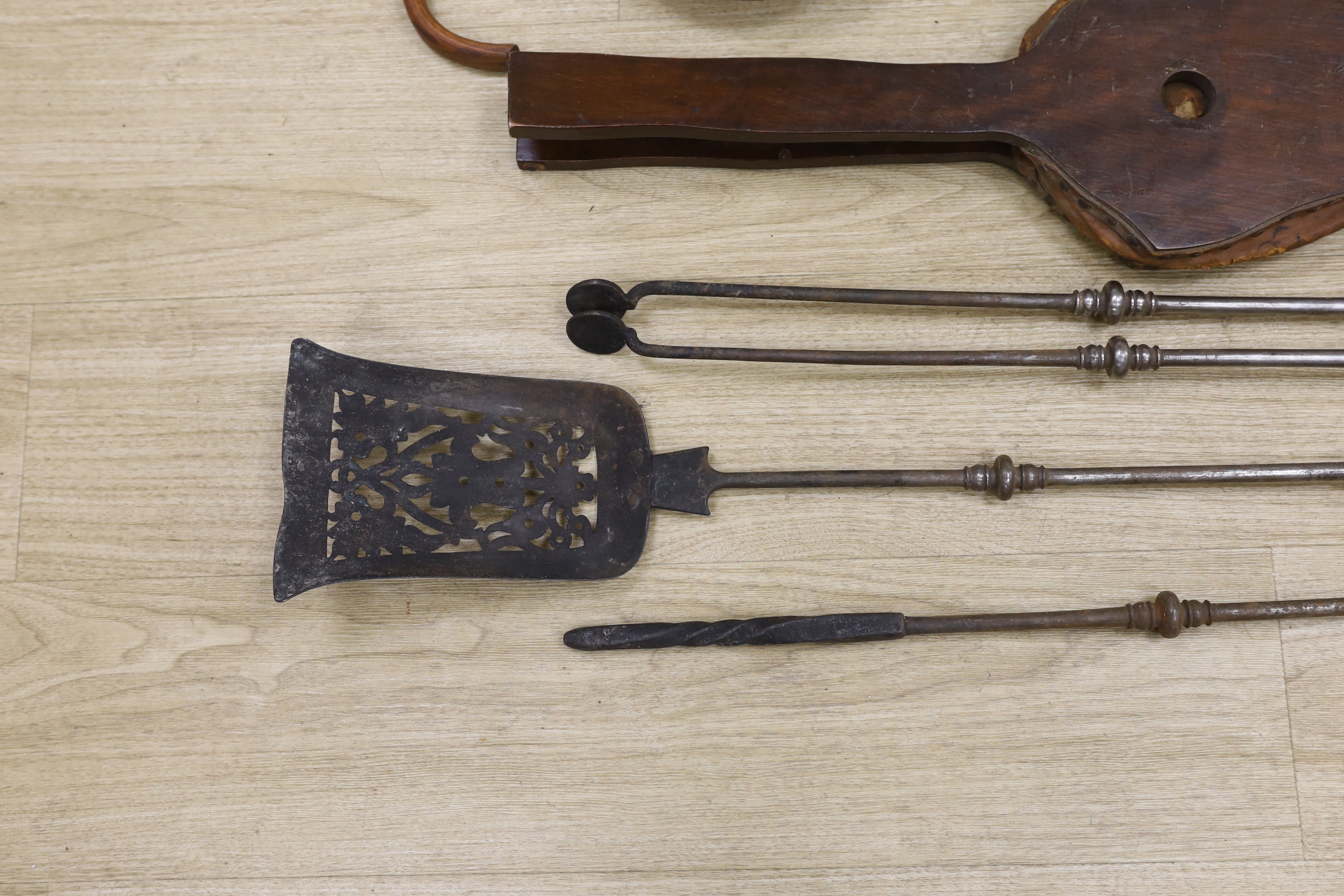 A set of three late Georgian steel fire irons, 79cm in length, together with a bellows and folding seat